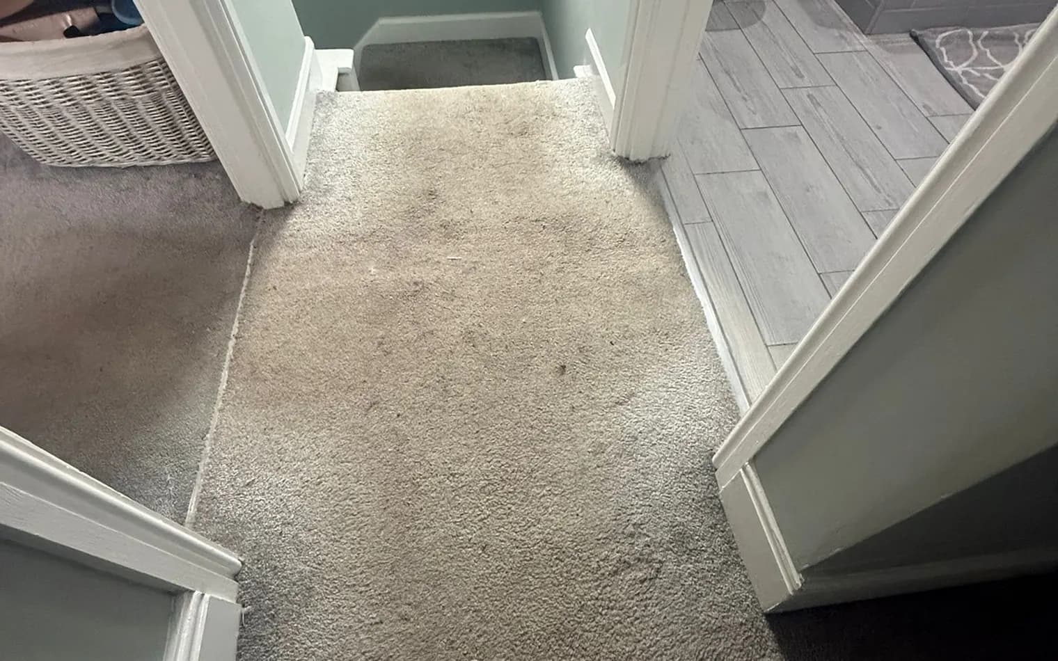 A landing carpet before the clean, with a dull, marked pile