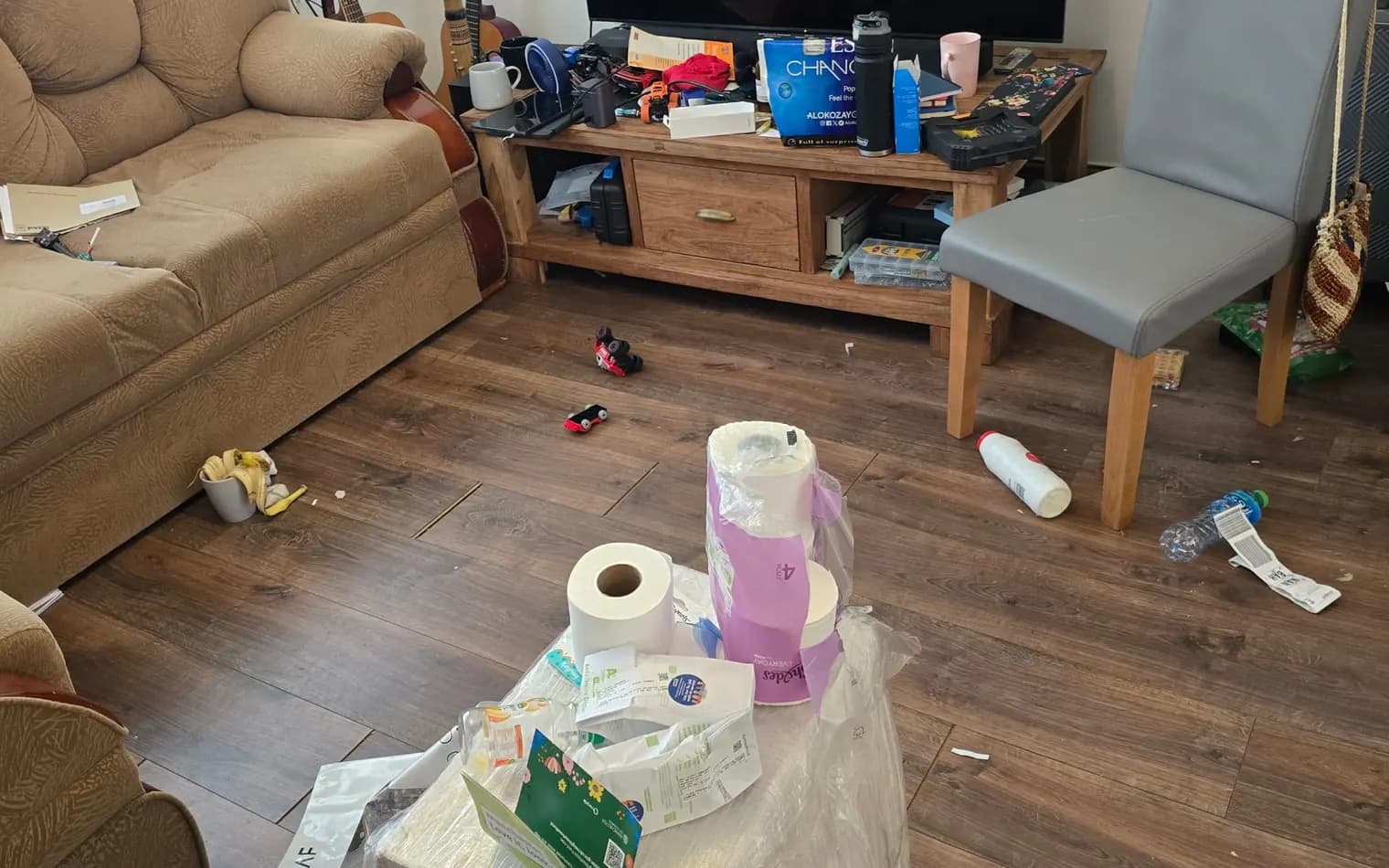 Living room before the deep clean, with clutter on the table and floor