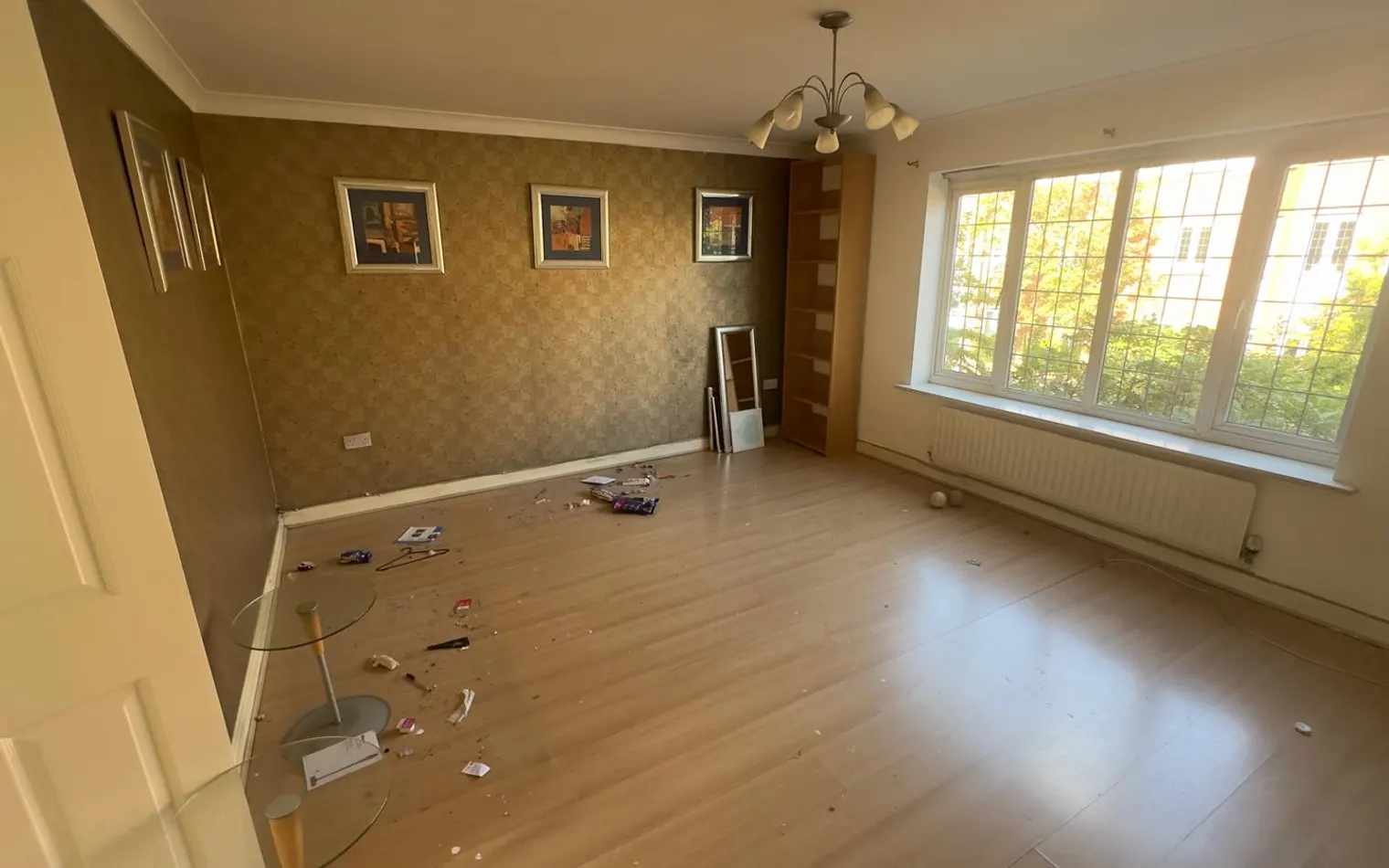 Living room before cleaning, with items left across the floor