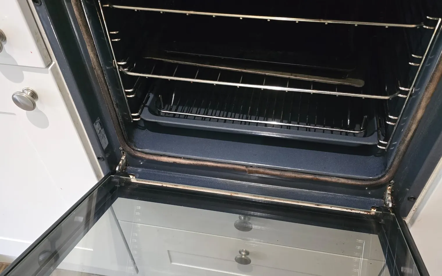 The same oven after the clean, with clean racks and clear door glass